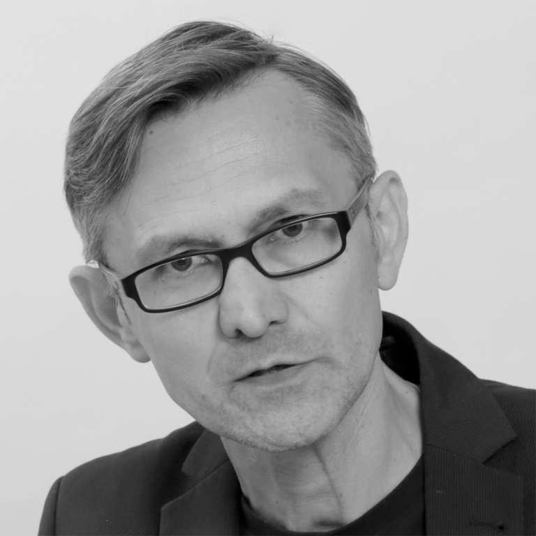 Czarno-białe zdjęcie- portret dr hab. Mariusza Dzięglewskiego, prof. UKEN (mężczyzny w średnim wieku w okularach)