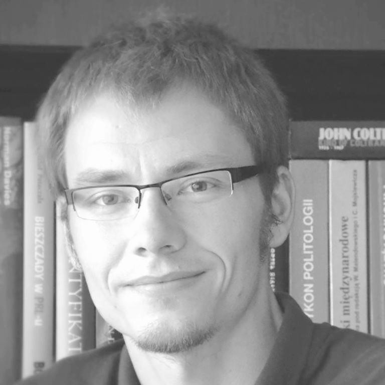 Czarno-białe zdjęcie: portret dr hab. Radosława Marzęckiego, prof. UKEN (mężczyzna w średnim wieku w okularach, uśmiech na twarzy)