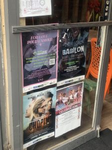 Cztery plakaty filmowe powieszone na witrynie sklepowej reklamujące filmy: "Tour l'amonr/Z miłości", "Babilon" i "Chopin. Nie boję się ciemności", a także plakat reklamujący wydarzenie "Polish Heritage Celebration"